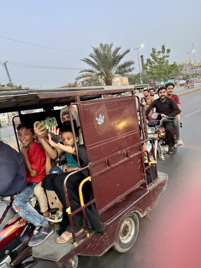 A group of people riding in the back of a truck.