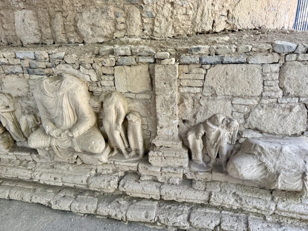 A stone wall with carvings of people and animals.