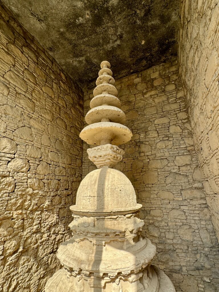 A stone wall with many stacked stones on top of it.